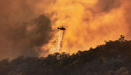 helicopter-throwing-water-on-forest-on-fire 