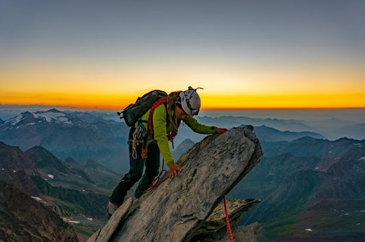 man-climbing-on-the-rock-sunset-view